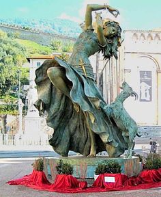 there is a statue that has a woman holding a bird on it's back