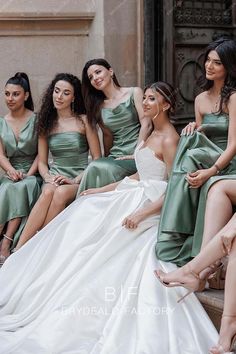 the bridesmaids are all dressed in different styles and colors, sitting on steps