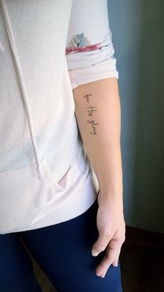 a person with a tattoo on their left arm and the word love is written in cursive writing