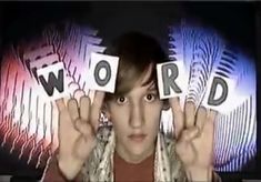 a man holding up two letters in front of his face with the word word spelled on them