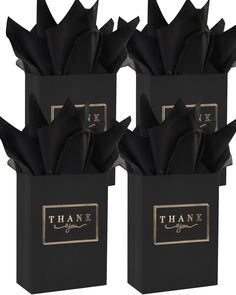 three black boxes with gold foiling and thank you written on the sides, each containing an individual's own name