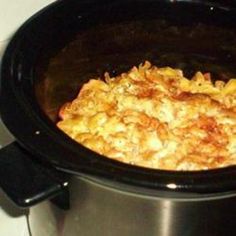 a crock pot filled with macaroni and cheese on top of a stove