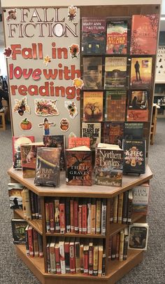 a book stand with books on it and a sign that says fall in love with reading