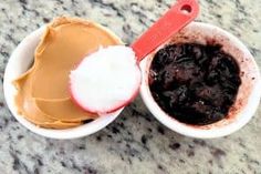 two cups filled with different types of desserts on top of a marble countertop