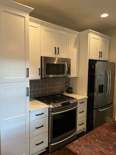 a kitchen with stainless steel appliances and white cabinets