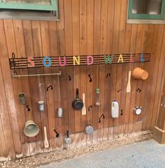 there is a sign that says soundwall on the side of a wall with many pots and pans