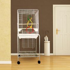 a white bird cage sitting on top of a wooden floor