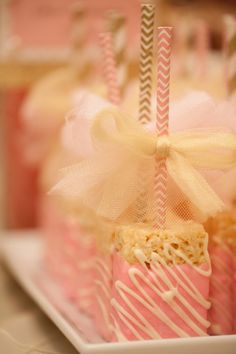 some pink and white cupcakes with candles in them sitting on a plate next to each other