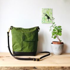 Crossbody bag - INCH - Green waxed canvas  - waterproof zipped shoulder purse - adjustable leather crossbody strap made by HOLM This bag provides just the right amount of space for your daily travel essentials - wallet, keys, water bottle, book etc.   Constructed with the best quality Scottish made waxed canvas specifically maufactured to be waterproof and withstand the rigours of any weather.  Brown leather base accompanies the look giving this crossbody the usual understated HOLM style. Full width best quality YKK zipper keeps your valuables stylishly safe .  The exterior has a handy slip pocket and the interior is lined in French striped ticking fabric with one zipped pocket to keep smaller items even more secure.  Fully adjustable shoulder / crossbody leather strap so that you can fit Green Waxed Canvas Bags With Adjustable Strap, Functional Crossbody Shoulder Bag With Waxed Finish, Functional Waxed Canvas Crossbody Shoulder Bag, Functional Waxed Finish Crossbody Shoulder Bag, Green Shoulder Bag With Waxed Finish For Daily Use, Green Leather Shoulder Bag With Canvas Lining, Outdoor Waxed Finish Crossbody Shoulder Bag, Green Shoulder Bag With Waxed Finish For Outdoor, Outdoor Green Shoulder Bag With Waxed Finish