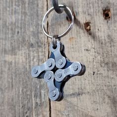 a metal keychain that is on top of a wooden table with chains attached to it