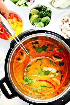 a pot filled with soup and vegetables on top of a table