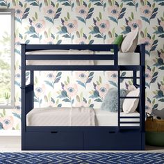 a blue bunk bed sitting in front of a window next to a flower wallpaper