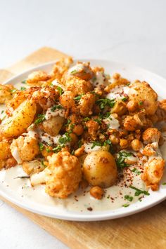 a white plate topped with cauliflower and potatoes