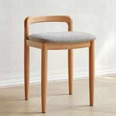 a wooden chair sitting on top of a hard wood floor next to a white wall