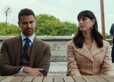 a man and woman sitting at a wooden table