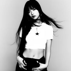 black and white photo of a woman with long hair wearing a cropped t - shirt