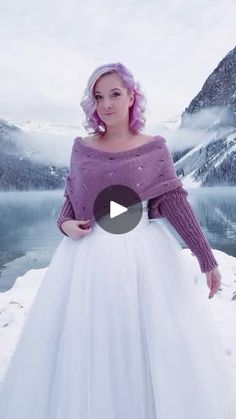 a woman with pink hair wearing a white skirt and purple sweater standing in the snow