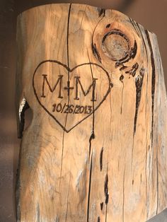 a piece of wood that has been carved into the shape of a heart with initials on it