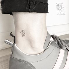 a woman's foot with a small tattoo on the side of her lower leg