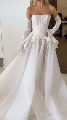 a woman wearing a white wedding dress with long sleeves