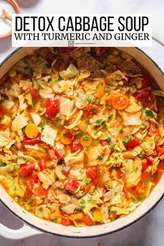 a large pot filled with cabbage soup on top of a white table next to a spoon