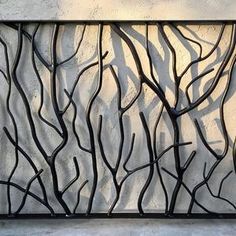 a metal wall sculpture with branches on it