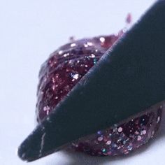 a close up of a piece of fruit with glitter on it and a knife sticking out of the top