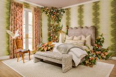 a bedroom decorated with flowers and greenery on the wall next to a large bed