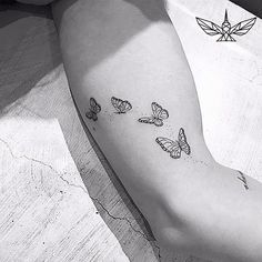 a woman's arm with three butterflies on the left side of her right arm