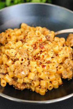 a bowl filled with macaroni and cheese on top of a black countertop