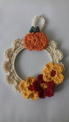 a crocheted wreath with two pumpkins on it