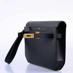 This Hermes Kelly Depeches Pochette, crafted in 2019, is a sleek and sophisticated embodiment of modern luxury and functionality. Made from Epsom leather, this material is renowned for its textured, scratch-resistant surface, ensuring durability and a consistently elegant appearance. The black color of the bag is a timeless classic, exuding an air of understated elegance and versatility, making it a perfect match for any outfit or occasion. The addition of gold hardware brings a touch of refined Luxury Black Travel Bag With Functional Pockets, Luxury Modern Black Travel Accessories, Hermes Clutch, Guys Style, Man Clutch, Timeless Bags, Hermes Kelly Bag, Hermes Men, Kelly Bag