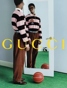 two young men standing in front of a mirror with the word gucci on it