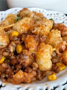 a white plate topped with corn and tater tots