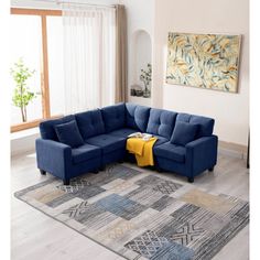 a blue sectional sofa sitting on top of a rug