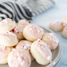 a plate filled with cookies covered in powdered sugar and sprinkled with candy canes