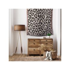 a room with a leopard print wall hanging over a dresser and lamp next to it