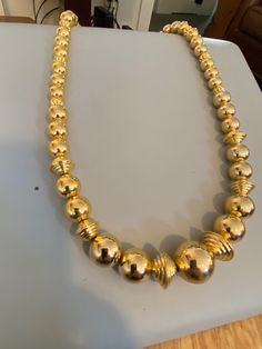 "From the estate of a woman who had a massive costume jewelry (mostly Avon) collection. This piece is a graduated gold bead necklace strung on a chain. Some of larger round beads toward the center of strand are flanked by large ribbed gold saucer beads. This necklace uses a spring ring closure. This piece is in excellent vintage condition. Signed: Korea Measurements Length: 28\" Largest Bead: .75\"" Gold Bead Necklace, Gold Beads, Bead Necklace, Spring Rings, Round Beads, Vintage Gold, Costume Jewelry, A Woman, Gold Tones