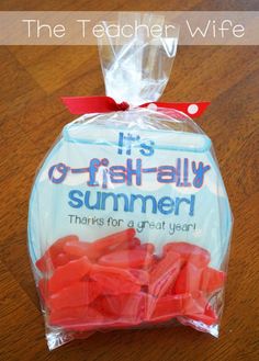 a bag of red gummy bears sitting on top of a wooden table next to a cell phone