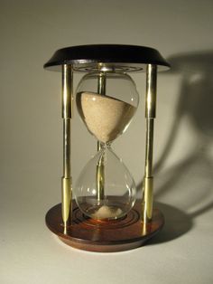 an hourglass sitting on top of a wooden stand