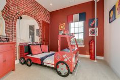 a child's bedroom decorated in red, white and blue with a fire truck bed