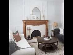 a living room filled with furniture and a fire place next to a fireplace in a white wall