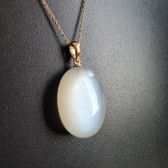 This stunning pendant is set in 14K Solid Yellow Gold with Natural White Moonstone with utmost precision. It is an unique gemstone pendant for nearly every occasion and is completely hassle-free jewelry. ITEM DETAILS * Gem: White Moonstone * Gem Size: 19X27mm * Gem Shape: Oval * Gem Weight: 31.49 carats * Gold Purity: 14KT  * Gold Weight: 0.47 gram * Total Weight of the Pendant: 6.77 gram The Gold purity is guaranteed and it comes with authentic 14KT gold hallmark. Since my items are handmade, they are absolutely nickel and lead free. Natural White Moonstones cabochon with drill setting and gold bail are studded on it with utmost precision.  CUSTOMIZATION * Gemstone customization is available and it can be substituted with a gem of your choice. Kindly message me for the same. PACKAGING * T White Oval Gemstones For Gifts, White Oval Cabochon Gemstones, Elegant White Cabochon Gemstones, White Pendant Gemstone For Gifts, White Pendant Gemstone Gift, Handmade Jewelry Box, Drill Set, White Moonstone, Bezel Pendant