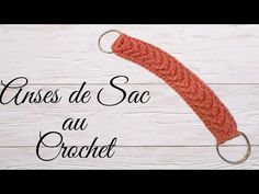 an orange crochet hook hanging from the side of a white wooden wall with text overlay