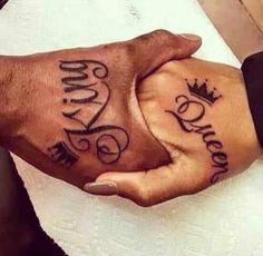 two hands holding each other with the words love and crown tattooed on their palms