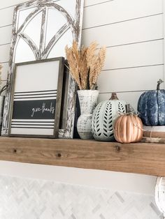 some pumpkins are sitting on top of a mantle