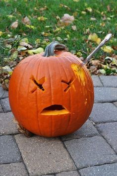 a pumpkin with its mouth open sitting on the ground