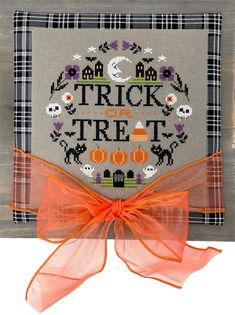 a cross stitch trick or treat bag with an orange bow