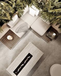 an aerial view of a living room with white furniture and plants in the corner area