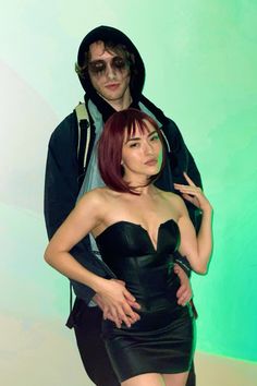 a man and woman dressed in black posing for the camera